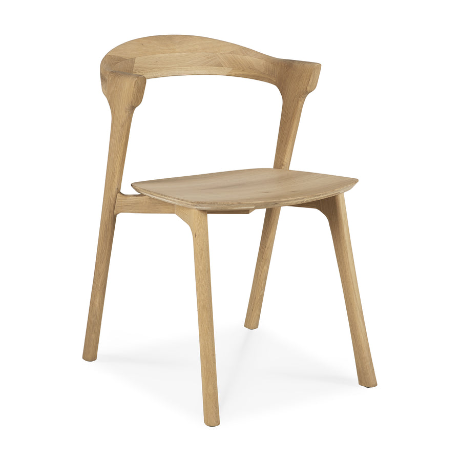 Ethnicraft Bok oak dining chair shown at a three-quarter side angle