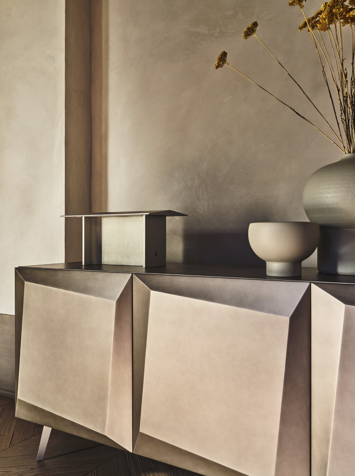 Supplier range detail of Alterego sculpted bronze doors; showroom photograph shows the actual three-door piece.