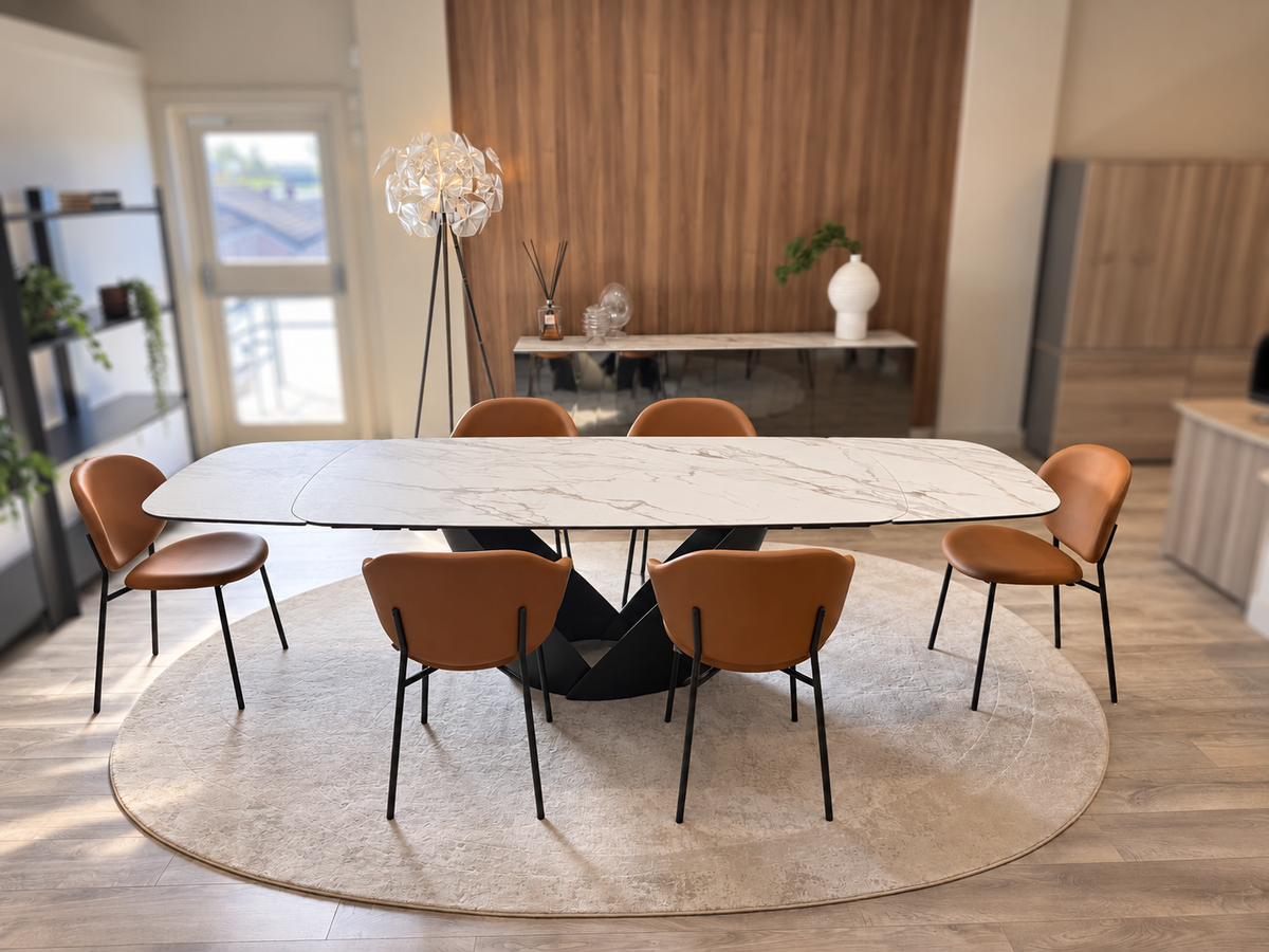 Actual Calla extending ceramic table with four Holly and two Inès cognac chairs, shown fully extended.
