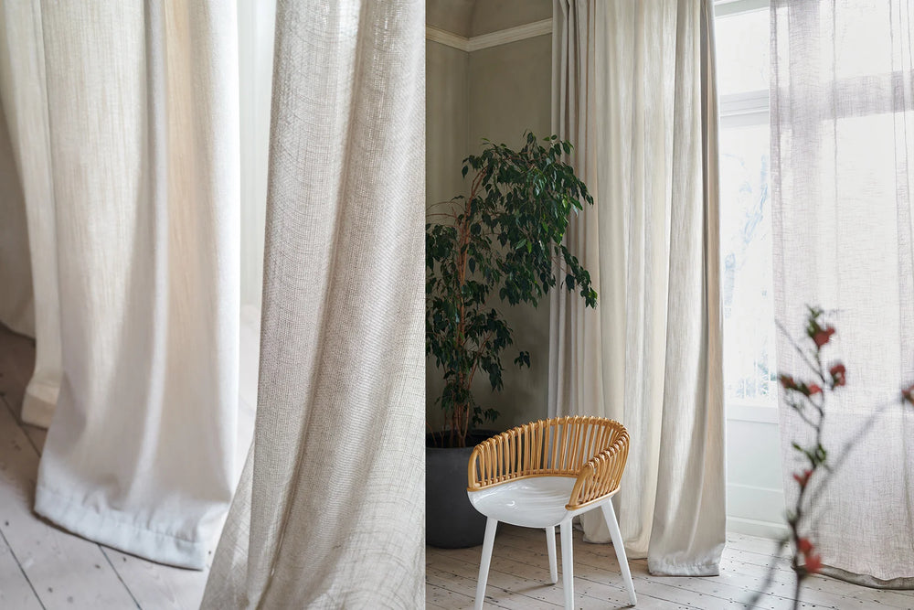Contemporary neutral curtains and translucent voiles by Designers Guild, beside a timber and white chair