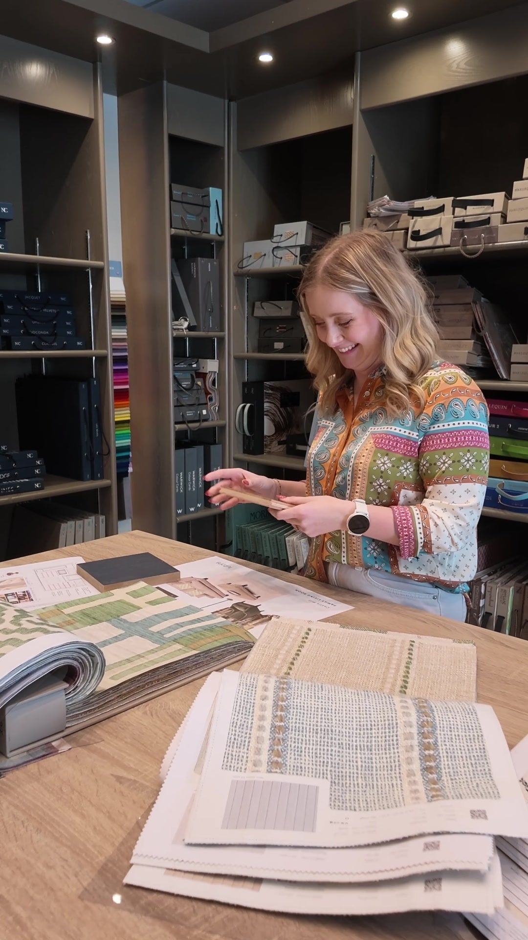 Emma comparing materials and room plans in the Fultons design studio