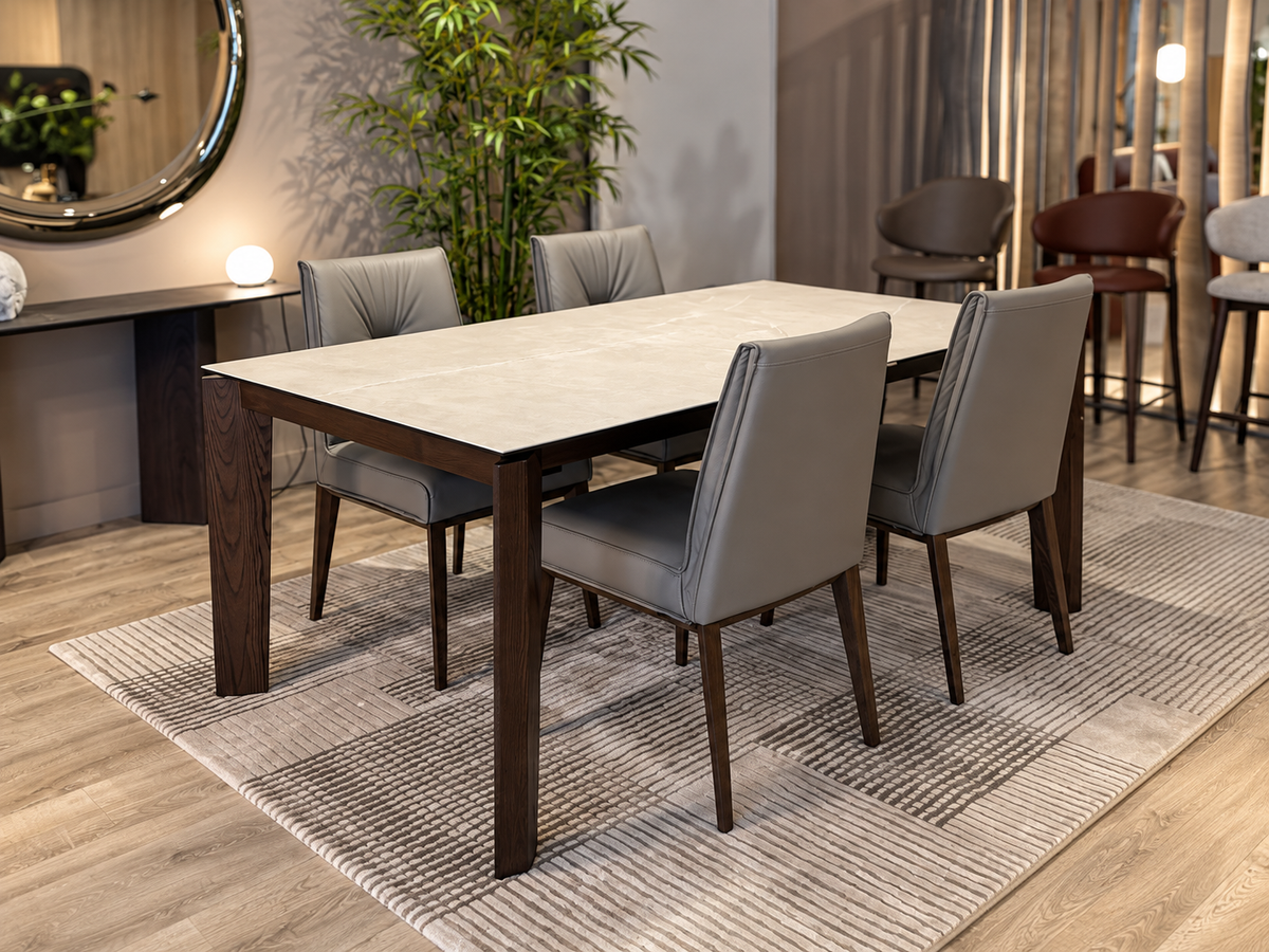 Calligaris Alpha table closed at 180 cm with four taupe leather Romy chairs — angled showroom view