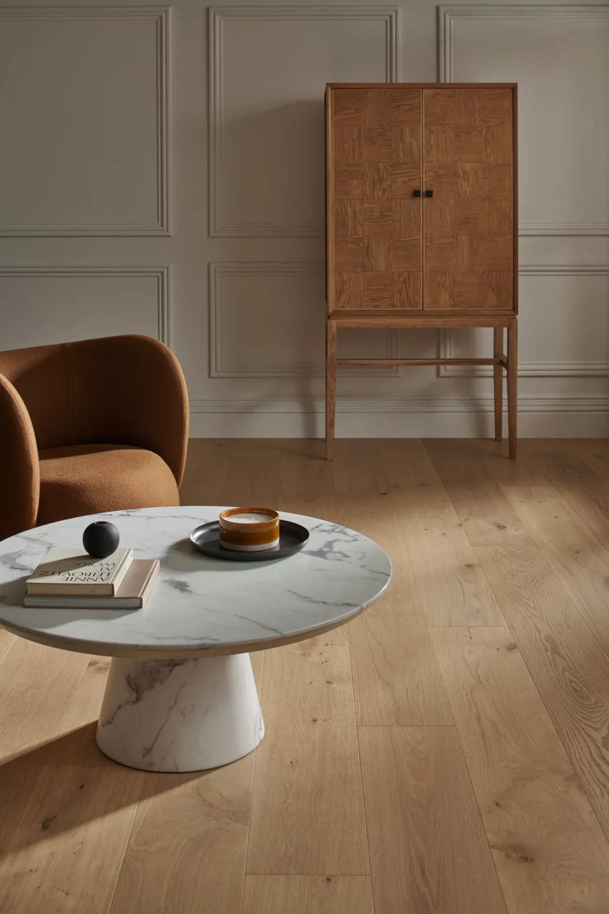 Woodpecker Harlech Raw Oak wooden flooring with a sculptural marble table and curved armchair — supplier inspiration