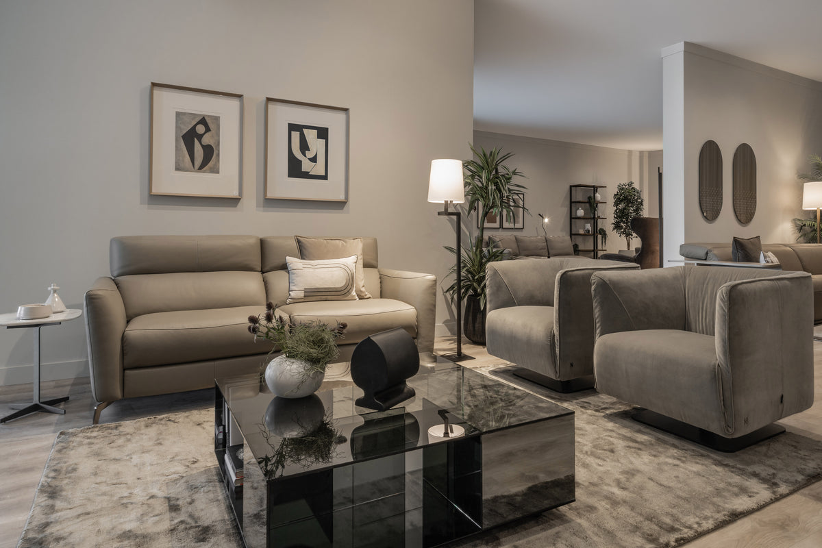 A coordinated living-room display at Fultons with a neutral sofa, upholstered armchairs, artwork and a glass coffee table