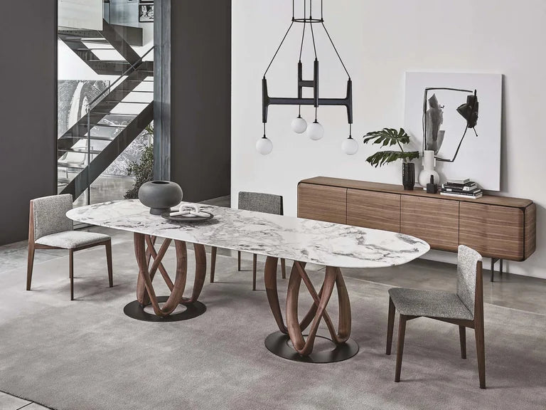 Porada Infinity dining table with sculptural walnut bases in a neutral dining room.