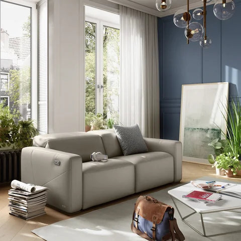 Natuzzi Editions Baltimora sofa in a bright room with a blue feature wall and wooden flooring