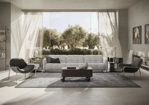 Natuzzi Italia Philo sofa in light upholstery beside a wooden coffee table and sheer curtains