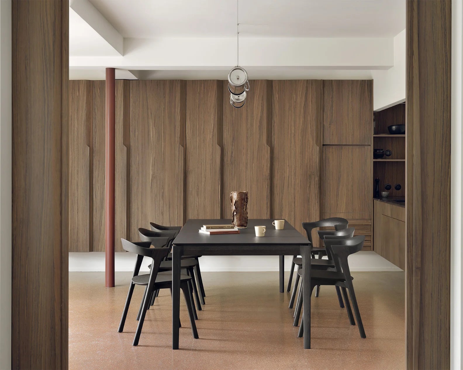 Ethnicraft dark oak Bok dining table and chairs in a wood-panelled dining room