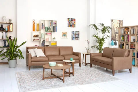 Natuzzi Editions Quiete sofa in tan upholstery with wooden coffee tables in a bright living room